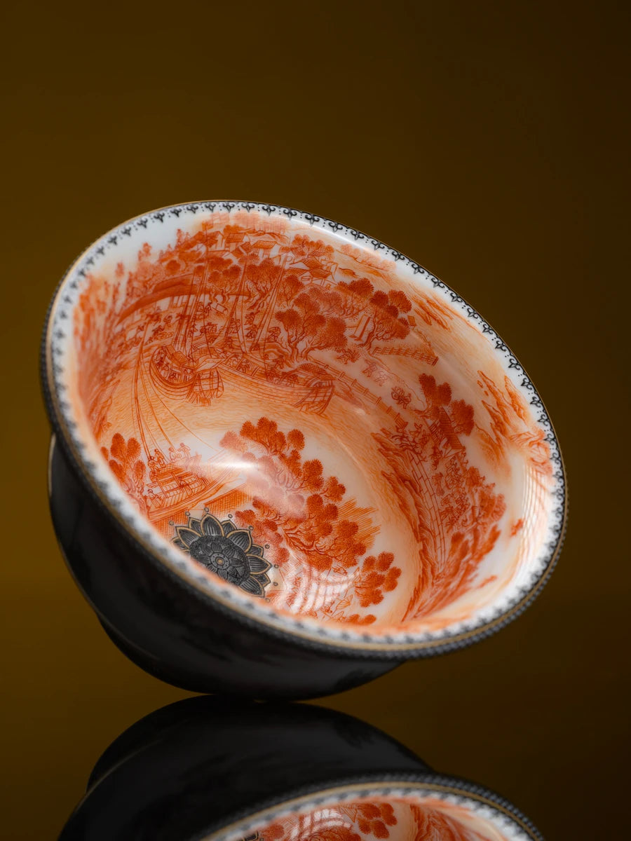 Orange river scene inside a dark porcelain bowl