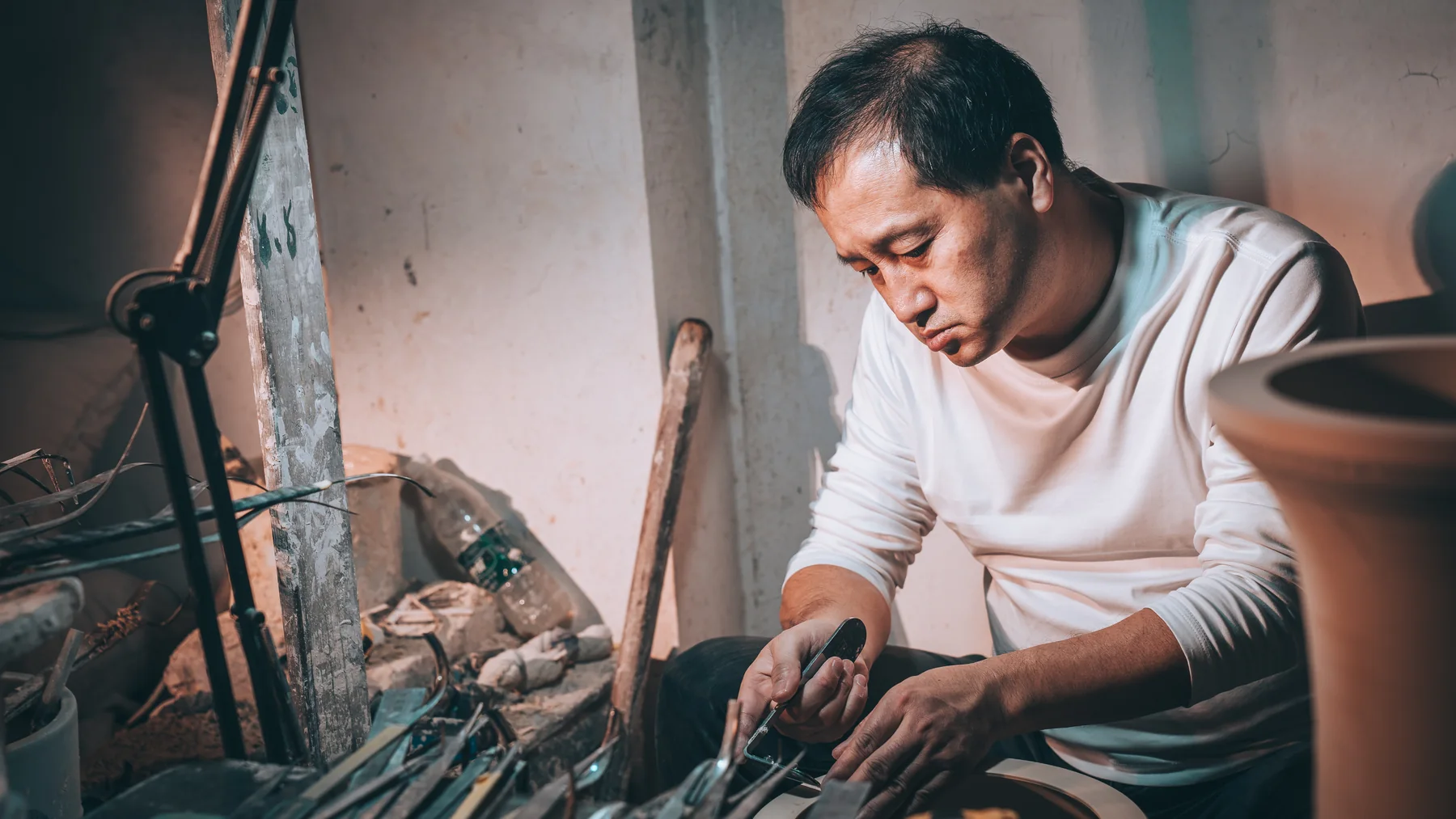 A porcelain artisan refining a vessel by hand
